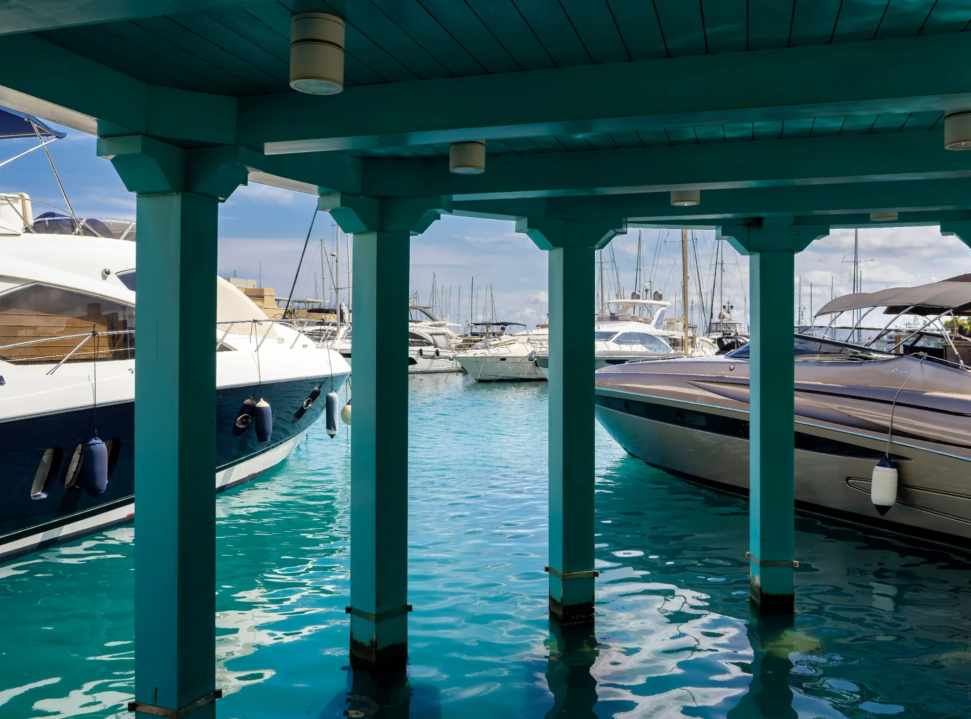 Jachtok a Limassol Marinában türkiz vízzel és kikötői részletekkel